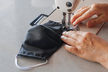 Handmade mask sewing from the fabric is used to prevent disease outbreaks with dust and germs close-up.