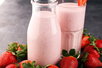 Glass of fresh strawberry shake, smoothie or milkshake and fresh strawberries on table. Healthy food and drink concept