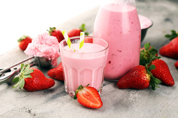 Glass of fresh strawberry shake, smoothie or milkshake and fresh strawberries on table. Healthy...