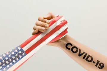 Human hands colored in flag of USA and coronavirus - concept of spreading of virus. Hands shaking is danger, the way of wordwide epidemic. Stay safe. Prevention, safety, pandemic spread concept Fight.
