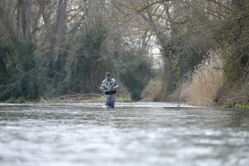 Fototapeta na wymiar fly fisherman in river in winter