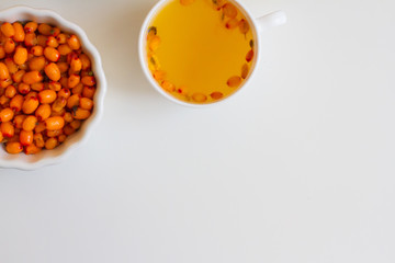 Vitamin useful sea buckthorn tea in a glass teapot with fresh sea buckthorn berries, orange, cinnamon sticks and honey. The concept of rest, relaxation. top view with a copy of the space