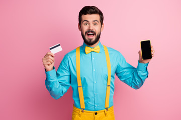 Portrait of his he nice attractive cheerful cheery glad bearded guy wearing mint blue shirt showing cell bank card wireless payment service app isolated over pastel pink color background