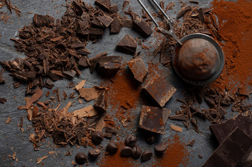 Dark chocolate crumbs and cocoa powder on slate stone