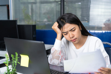 serious worried businesswoman or student asian reading notification paperwork or documents sitting in a desktop at office with information laptop, working in sad and anxiety about accounting corporate