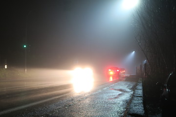 Auto nella notte con nebbia e fanali