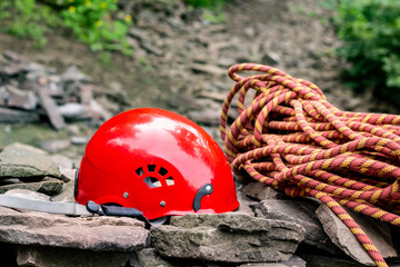 Climbing sport tools: hard hat, rope, carabiner. Mountaineering equipment on rocks