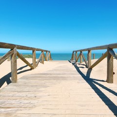 Summer holiday background - wooden bridge leading to the sea