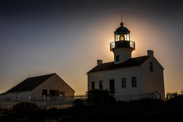 The sun sets over San Diego, California giving off a spectacular glow behind the Old Point Loma Lighthouse.