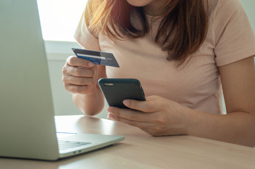 Young woman use credit card for shopping  payment online on laptop computer application or website. E-commerce and online shopping concept. Stay home and Buy products online.