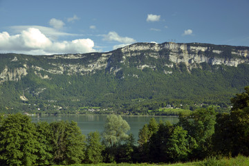 Fototapeta na wymiar View of the alpine lake Aiguebelette, at the feet of a big mountain.