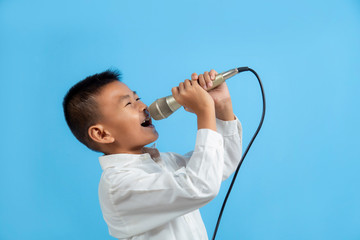 Asian boy singing with microphone