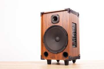 Portable speaker box with amplifiers on wood table on white background