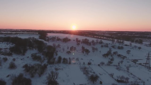 Flying in winter over snowy hills beautiful sun at sunset cold frosty evening