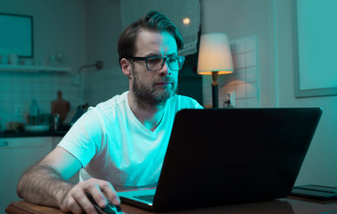Businessman working on laptop computer at home by night