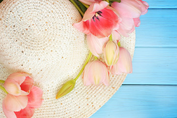 Spring flowers tulips with a straw sun hat