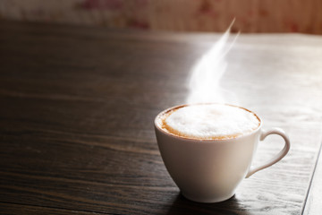 cup of cappuccino coffee on wooden background