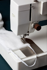  A medical mask is sewn on a sewing machine.