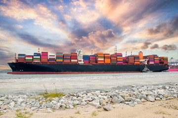 Logistics and container loading by large barges by sea in a harbor full of containers waiting to be...