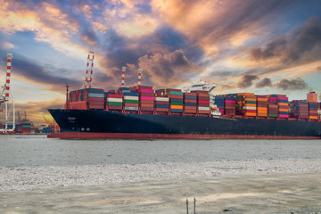 Logistics and container loading by large barges by sea in a harbor full of containers waiting to be...