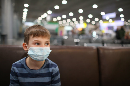 Child with a face mask to protect himself from the coronavirus while waiting in the terminal of an airport in europe