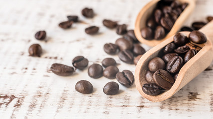 coffee beans in wooden spoons on rustic wooden old background. Macro