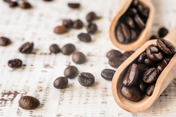 coffee beans in wooden spoons on rustic wooden old background. Macro