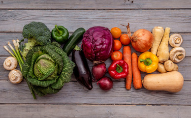 Selection of fresh vegetables arranged in a rainbow on a rustic background