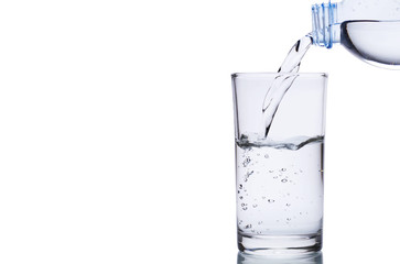 Pouring water into glass isolated on white