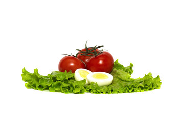 red, ripe tomatoes and boiled chicken eggs on a fresh lettuce leaf, isolated on a white background