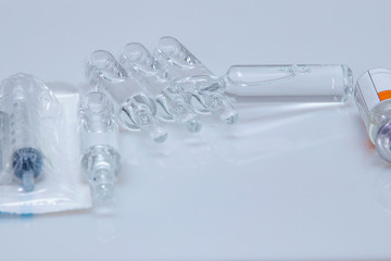 Injectable medicine in glass ampoules. Disposable sterile syringe in a package.
