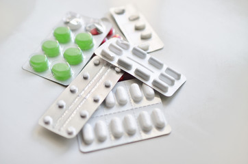  many different pills in blisters. Photo on a white background with bokeh.