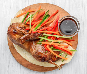 baked duck with vegetables on a wooden background