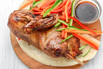 baked duck with vegetables on a wooden background