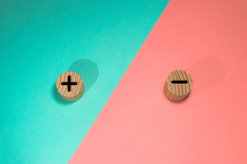Pros and cons concept, Hand choose wood blog with plus and minus on blue and pink background, flat...