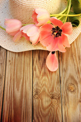 Spring flowers tulips with a straw sun hat