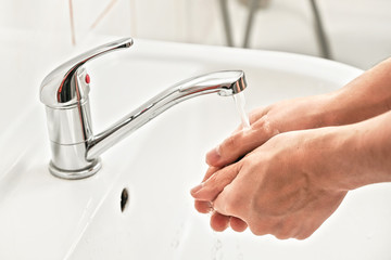 Man washing hands under water tap faucet. Personal hygiene concept, can be used during covid-19 coronavirus outbreak
