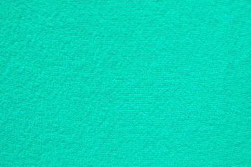 A simple example of a texture of soft, fleecy fabric, a green background.