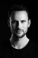 Black and white studio portrait of a man with a short beard