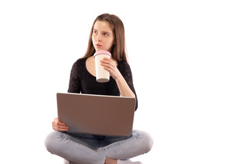 girl with a laptop sitting, drinking tea and looking to the side