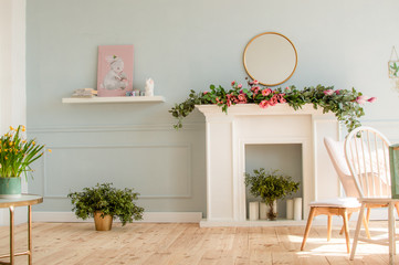 Home interior in blue tones with easter decoration. Spring flowers in a vase and blue Easter eggs...