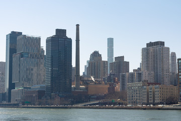 Fototapeta premium Panoramę Nowego Jorku w Upper East Side wzdłuż East River z czystym błękitnym niebem
