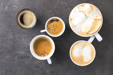 Different cups and mug with different type of coffee on dark concrete background. Top view of Cappuccino, Espresso,Americano, Mocca, Latte for assortment coffee concept.