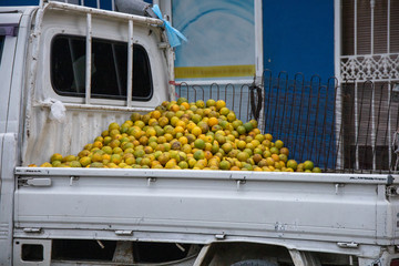 Heap or pile of oranges on sale on the back of a truck in small town or village in the dominican...