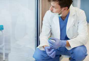 Tired and thoughtful doctor at hospital corridor
