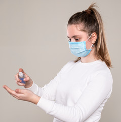 Teen girl applying alcohol spray or anti bacteria spray to prevent spread of germs, bacteria and virus