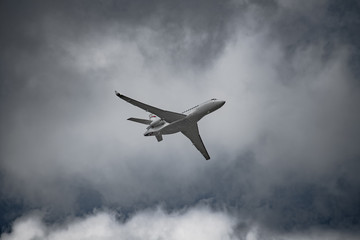 Fototapeta na wymiar Airplane in the sky - cloudy day. Dramatic cloudy sky.