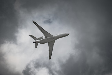 Airplane in the sky - cloudy day. Dramatic cloudy sky.
