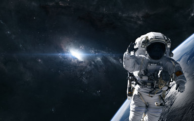 Astronaut on the background of a bright star in the center of the galaxy. Deep space planet. Science fiction. Elements of this image furnished by NASA