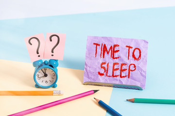 Text sign showing Time To Sleep. Business photo showcasing a natural period of slumber or to be in state of inactivity Mini size alarm clock beside stationary placed tilted on pastel backdrop